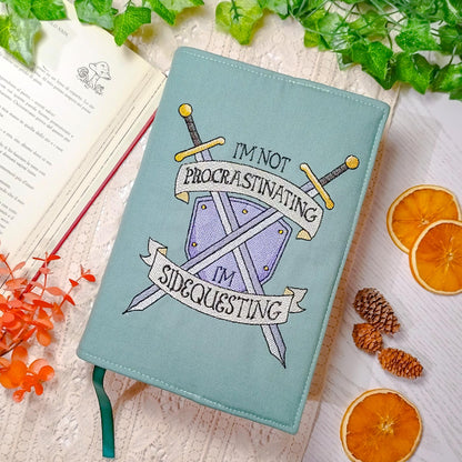 Book cover ricamata "I'm not procastinating" | Custodia per libri regolabile